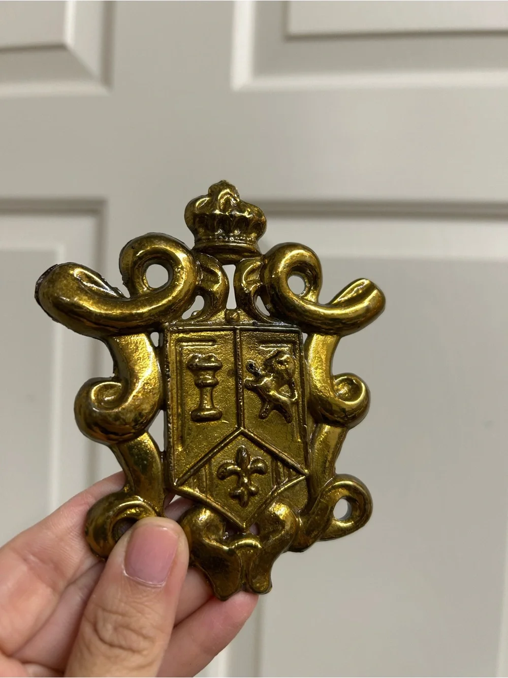 vintage gold-toned or brass-plated metal coat of arms or family crest decorative